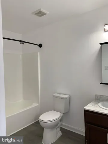 a white toilet sitting next to a bath tub