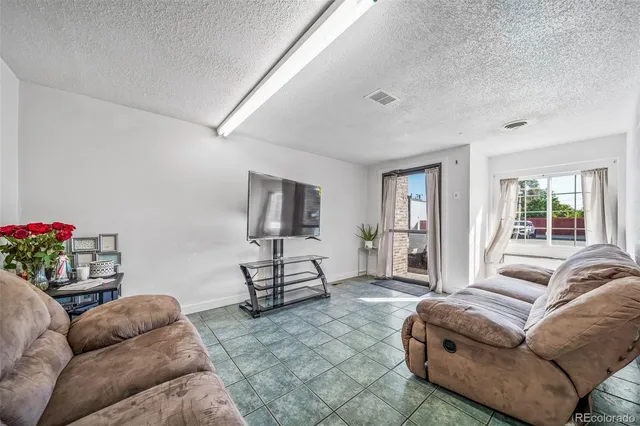 a living room with furniture a flat screen tv and a window