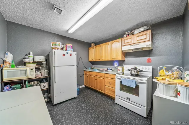 a kitchen with refrigerator a stove a sink dishwasher and white cabinets with wooden floor