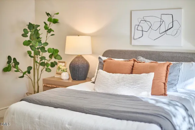 a bedroom with a bed and a potted plant