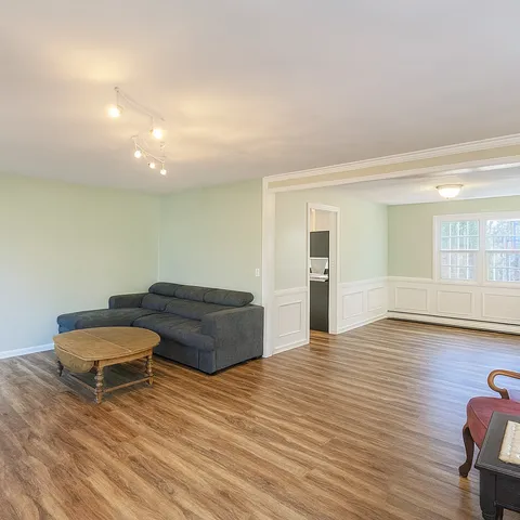 a living room with furniture and a wooden floor