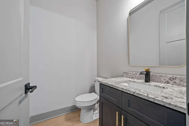 a view of an empty room with a kitchen and a window
