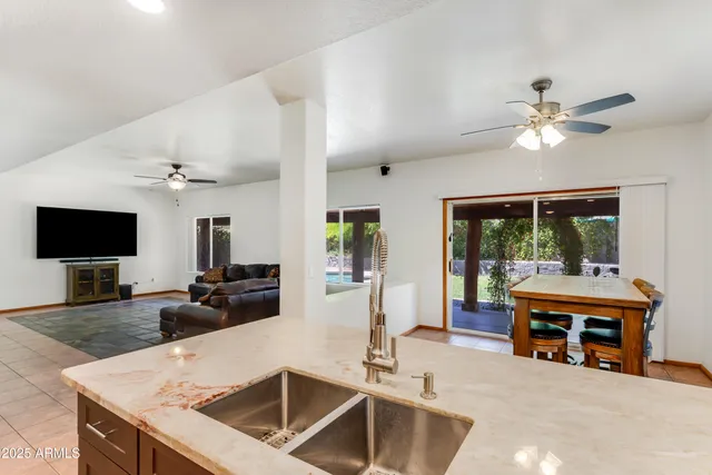 a living room with furniture a flat screen tv and a chandelier