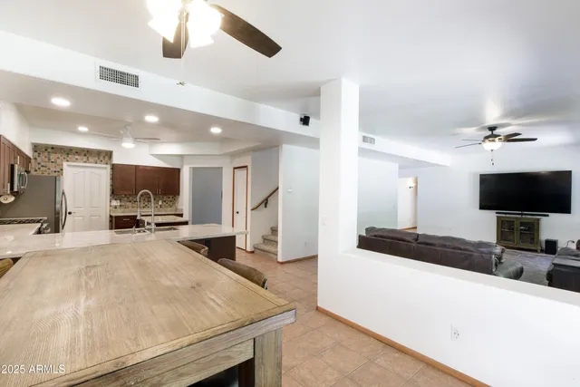 a large white kitchen with a large island in the center