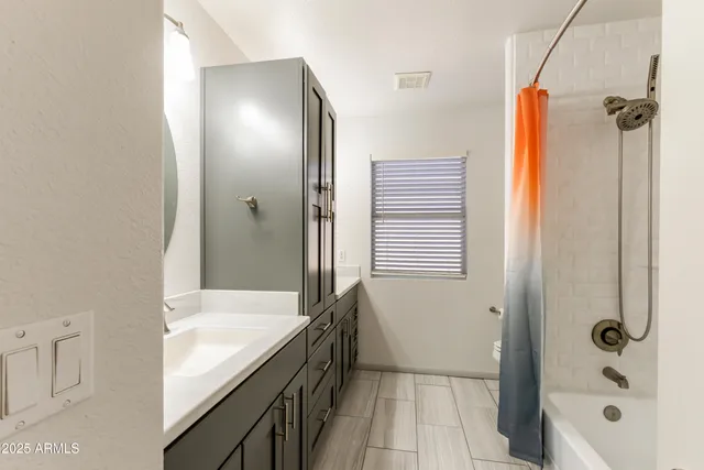 a bathroom with a tub shower and sink