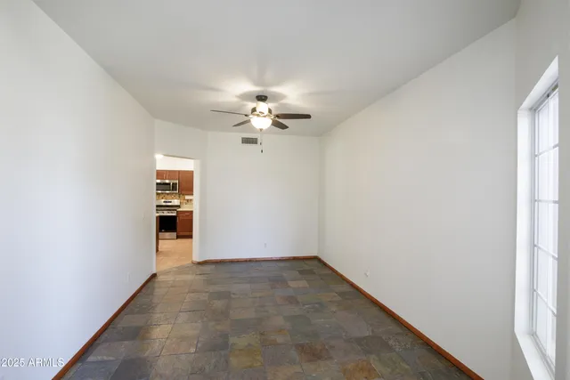 an empty room with windows and fan