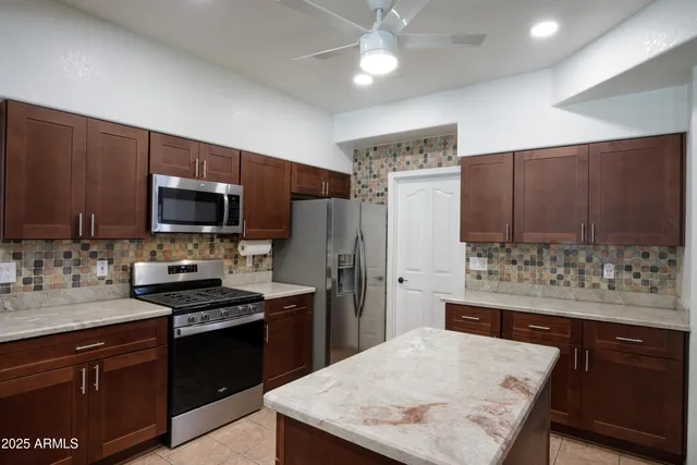 a kitchen with stainless steel appliances a stove refrigerator sink and microwave