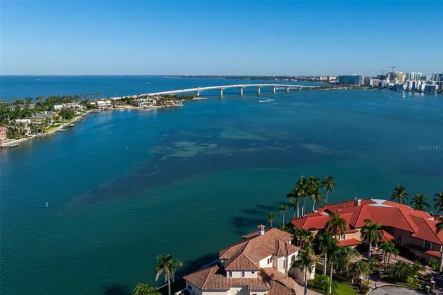 an aerial view of a city with lots of residential buildings and ocean view in back