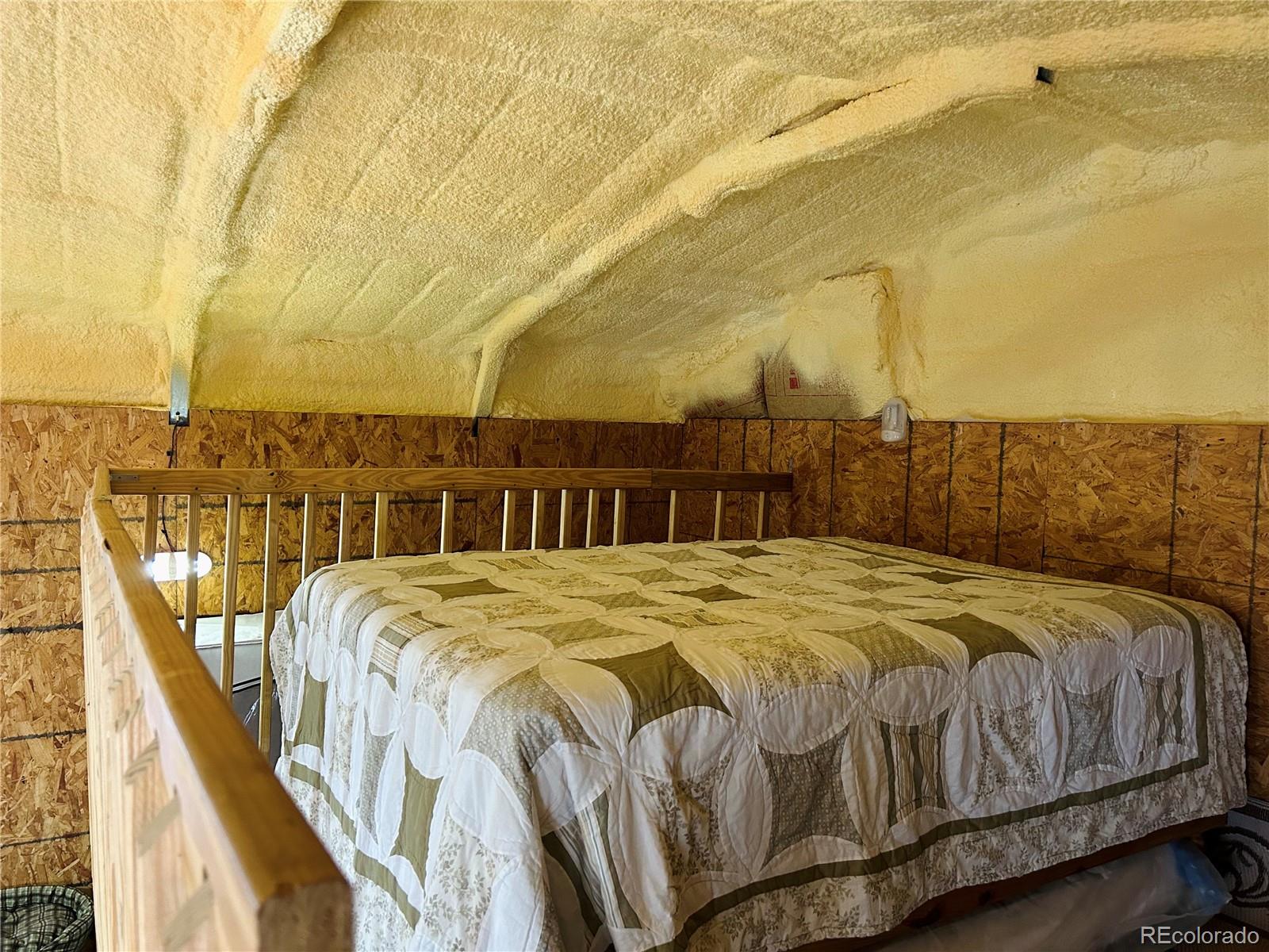 4535 Sarnoff Road Fort Garland, CO 81133 - Photo 12 of 44 a bed sitting in a bedroom next to a large window