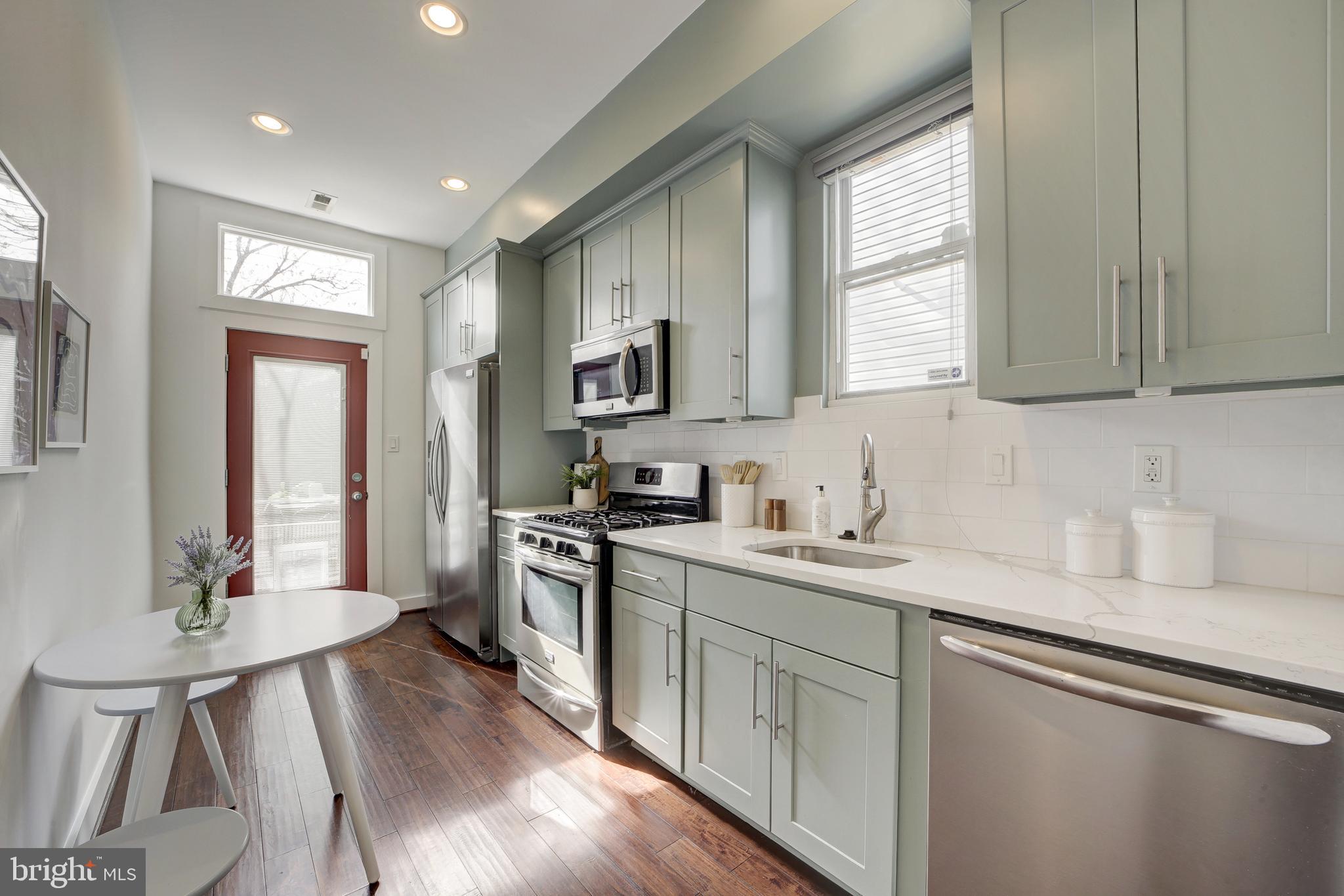 2012 2nd Street Northwest Washington, DC 20001 - Photo 14 of 28 a kitchen with a sink stove cabinets and wooden floor