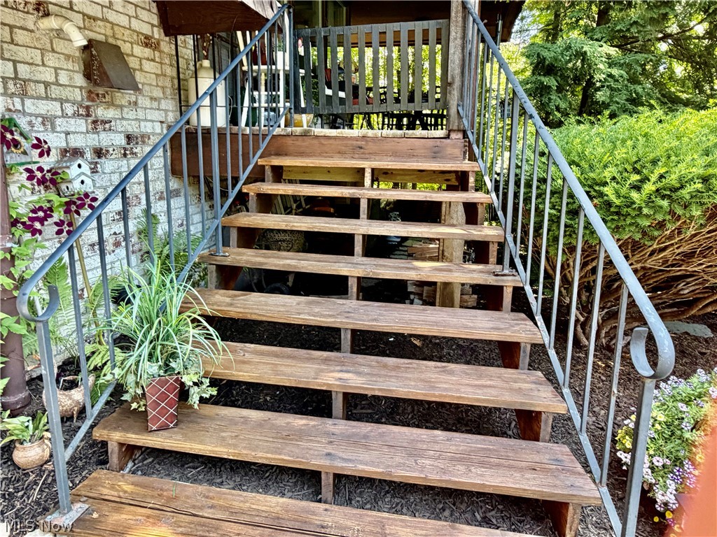 171 Granger Road, Unit 107 Medina, OH 44256 - Photo 3 of 41 Wood-finish stairs featuring metal railings and a brick exterior