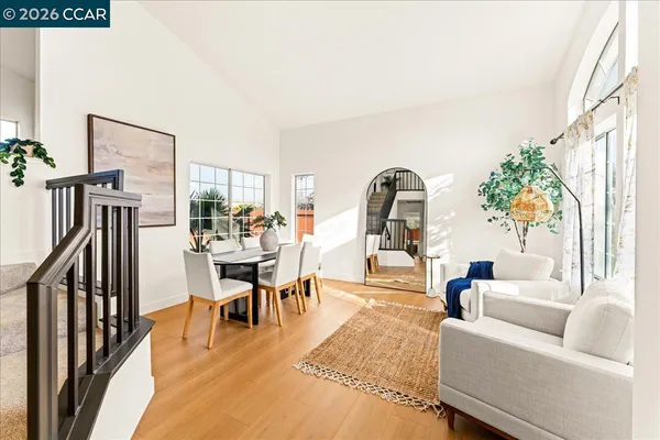 a living room with furniture a dining table and wooden floor