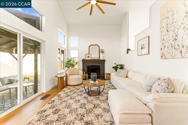 a living room with furniture a large window and a fireplace