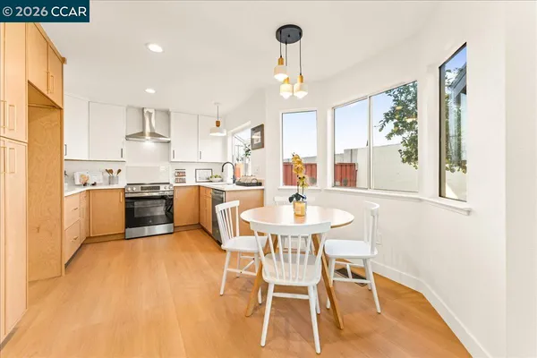 a kitchen with a table chairs a sink dishwasher window and cabinets