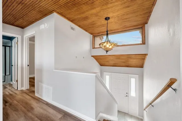 a view of a hallway with wooden floor and entryway
