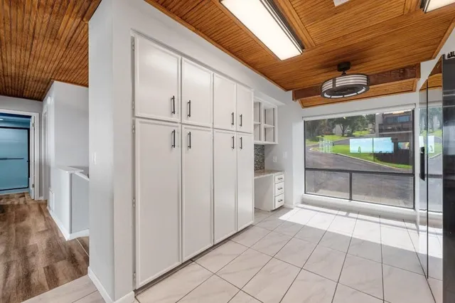 a view of a refrigerator in kitchen and an empty room