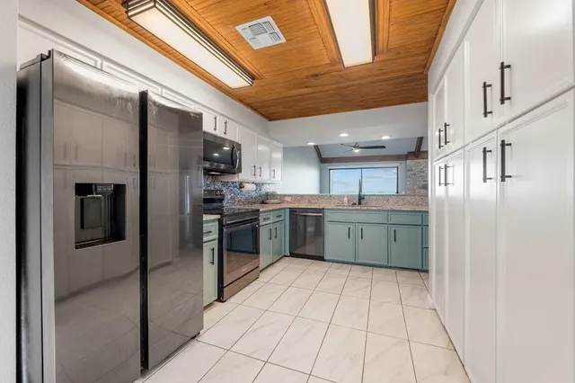 a kitchen with stainless steel appliances granite countertop a refrigerator and a sink