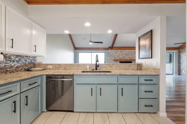 a kitchen with white cabinets appliances and a sink