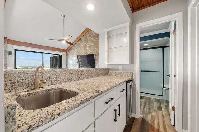 a kitchen with a granite countertop sink and refrigerator