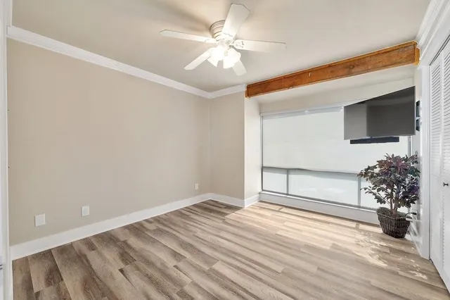 a view of a livingroom with wooden floor and a ceiling fan