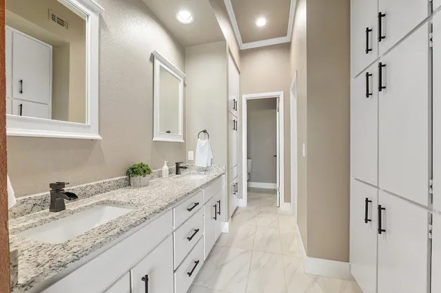 a bathroom with a granite countertop sink mirror and vanity