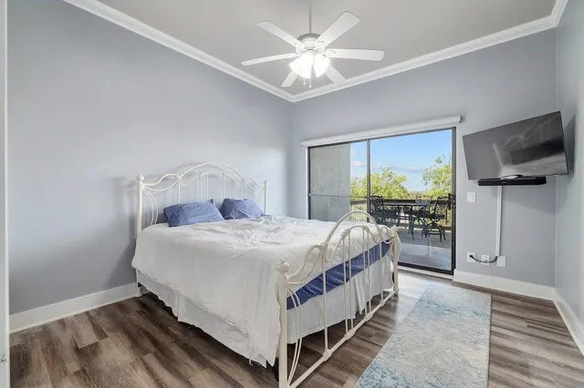 a bedroom with a bed and a flat tv screen on dresser