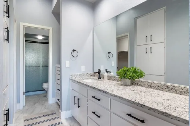 a bathroom with a granite countertop sink and a mirror