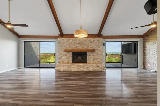 a view of an empty room with a fireplace and a window