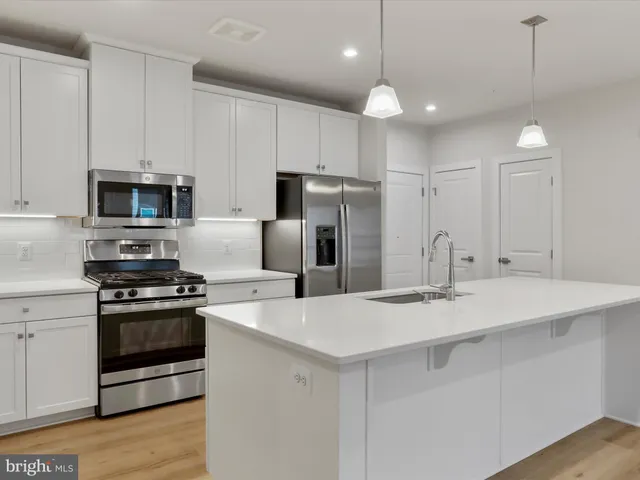 a kitchen with kitchen island a sink stainless steel appliances and cabinets