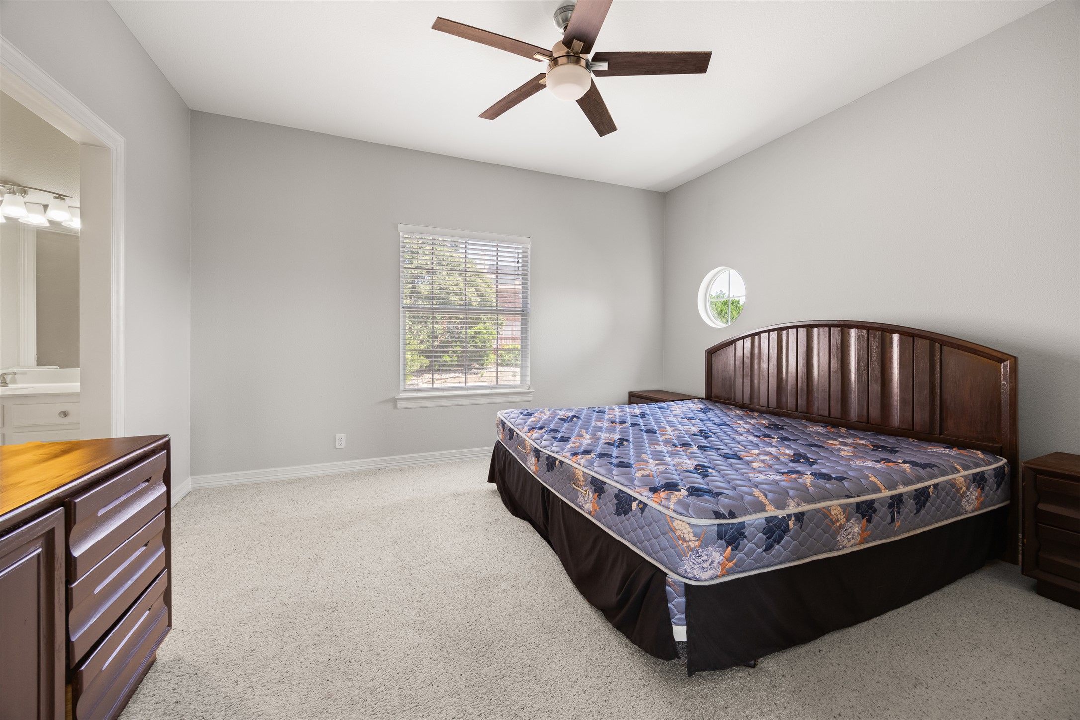 9300 Simmons Road Austin, TX 78759 - Photo 14 of 17 A well-proportioned bedroom offers comfort and a tranquil atmosphere with a ceiling fan and natural light.
