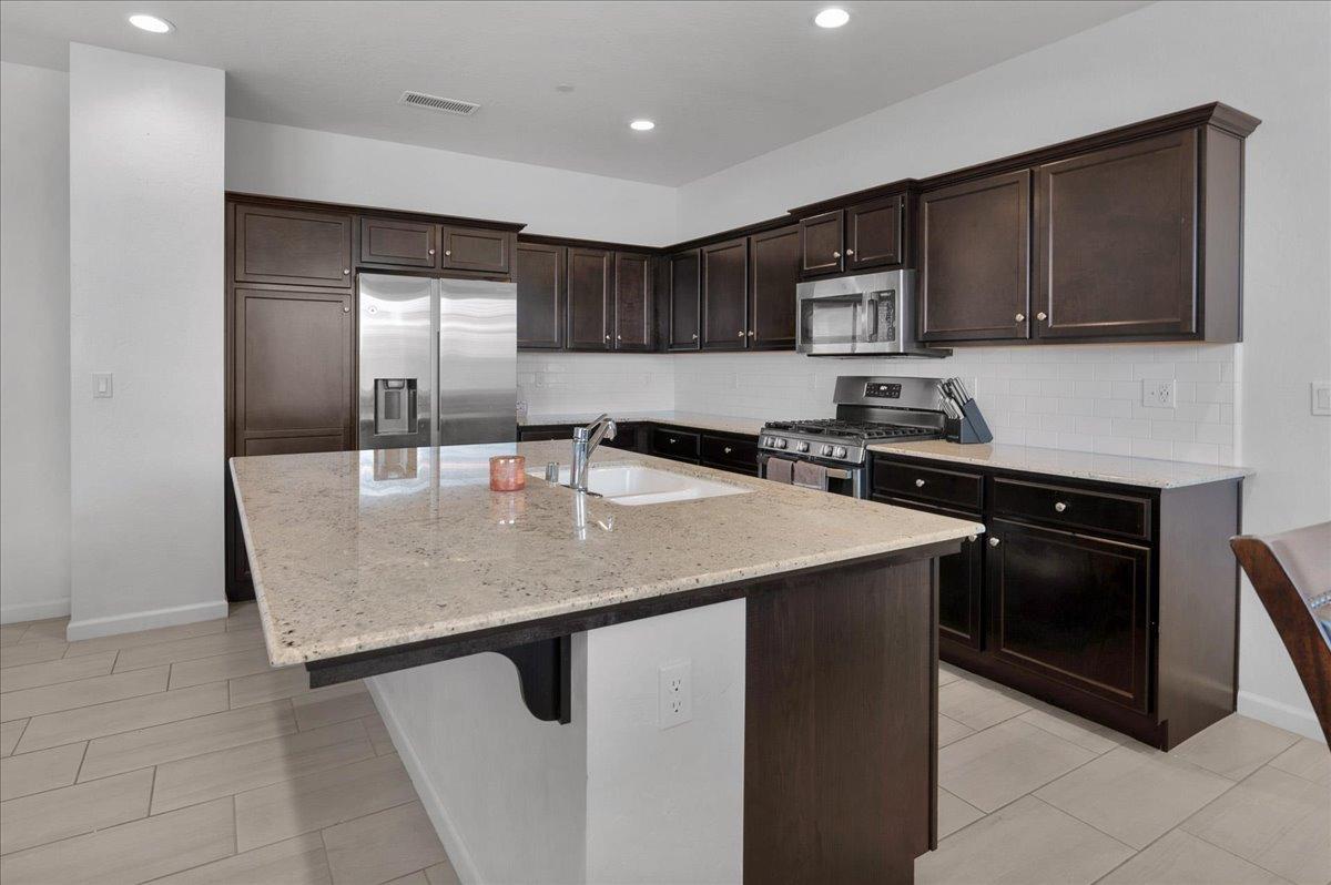 3012 Swift Lane Clovis, CA 93619 - Photo 6 of 40 a kitchen with stainless steel appliances granite countertop a sink dishwasher a stove and a refrigerator with wooden floor