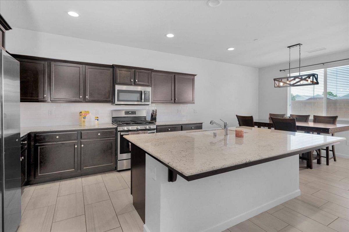3012 Swift Lane Clovis, CA 93619 - Photo 9 of 40 a kitchen with stainless steel appliances granite countertop a sink stove and refrigerator
