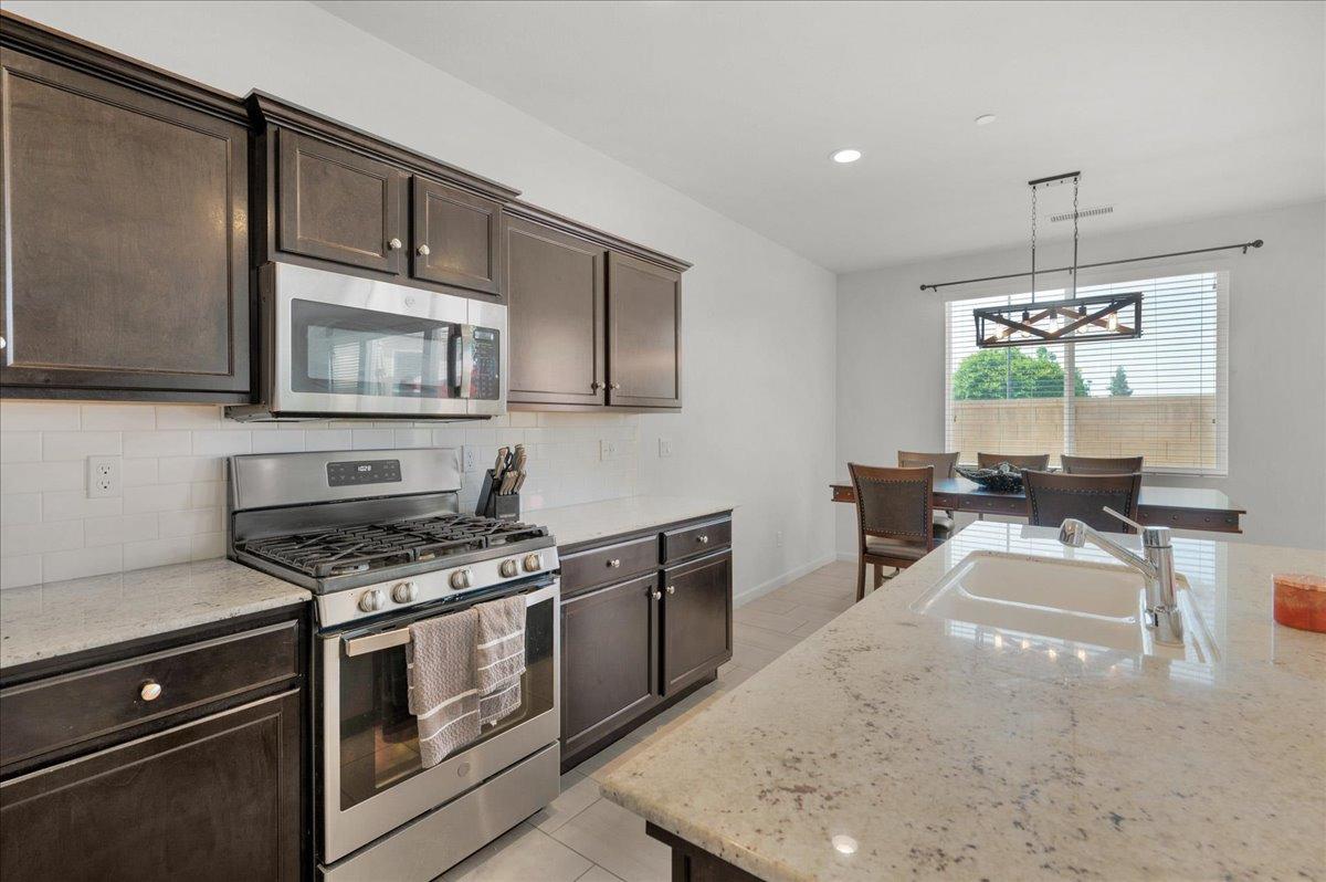 3012 Swift Lane Clovis, CA 93619 - Photo 10 of 40 a kitchen with stainless steel appliances granite countertop a stove a sink and a microwave