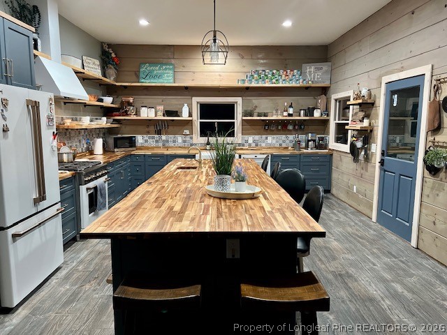 4119 Minnie Hall Road Autryville, NC 28318 - Photo 2 of 16 a large kitchen with stainless steel appliances granite countertop a stove a refrigerator a sink a dining table and chairs with wooden floor