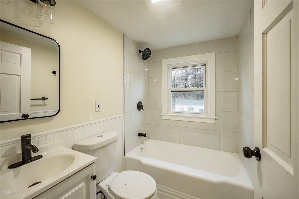 1174 Liberty Street Springfield, MA 01104 - Photo 19 of 34 a bathroom with a bathtub toilet sink vanity and mirror