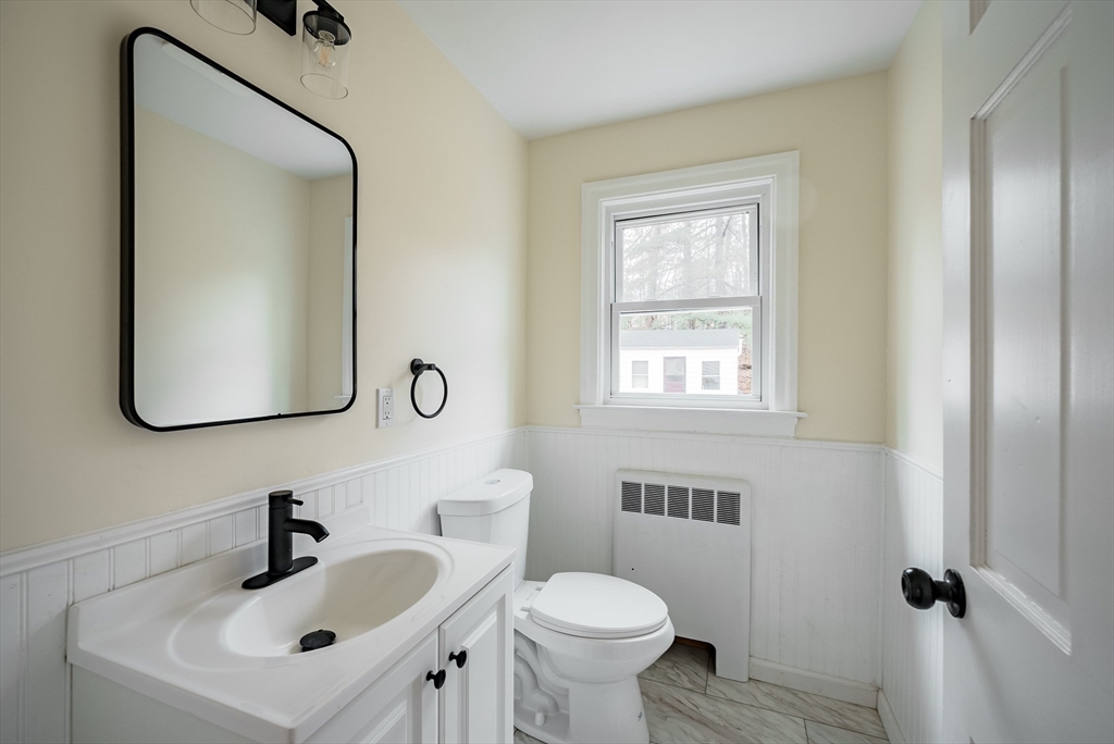 1174 Liberty Street Springfield, MA 01104 - Photo 6 of 34 a bathroom with a sink a toilet and a mirror