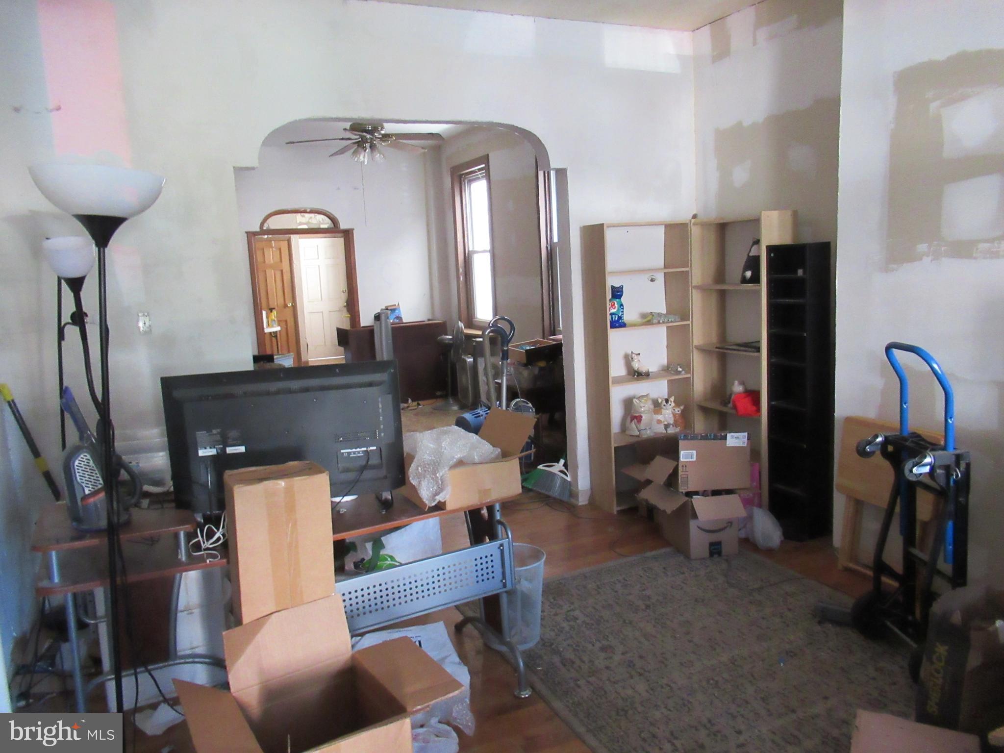 4953 Hawthorne Street Philadelphia, PA 19124 - Photo 2 of 9 a living room with furniture a large mirror and chairs