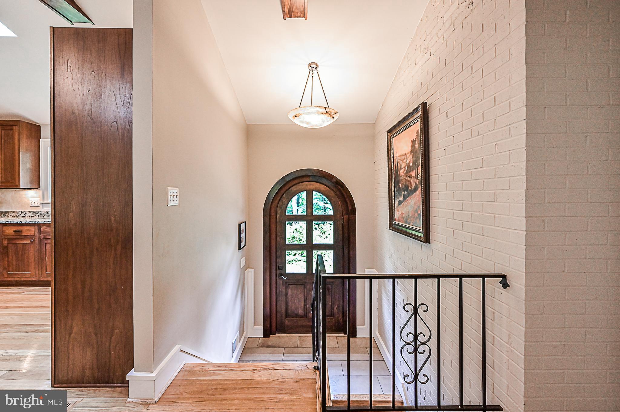 10600 Hunters Valley Road Vienna, VA 22181 - Photo 3 of 50 Custom Oversized Door in Foyer w/ Stone Chandelier