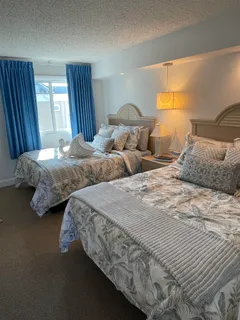a bedroom with two beds and lamp