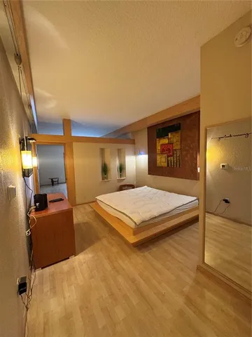 a bedroom with a bed and wooden floor