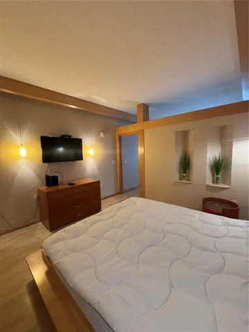 a bedroom with a bed and a flat screen tv