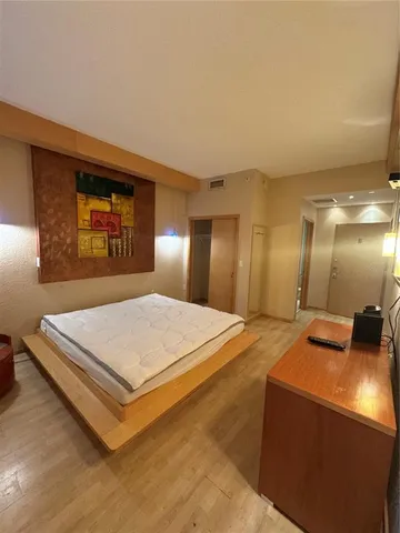 a spacious bedroom with a bed and a chandelier