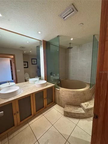 a spacious bathroom with a tub a sink and a mirror