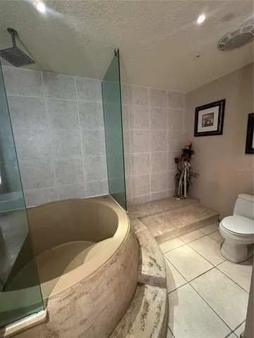 a bathroom with a granite countertop bathtub and toilet