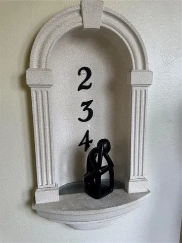 a close view of a sink a mirror and a potted plant on a wall