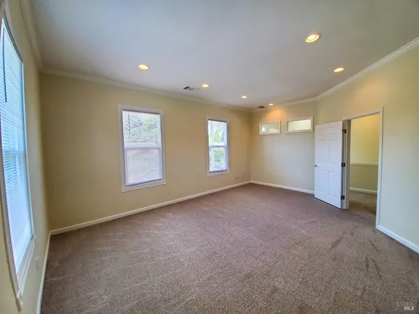 an empty room with windows and closet