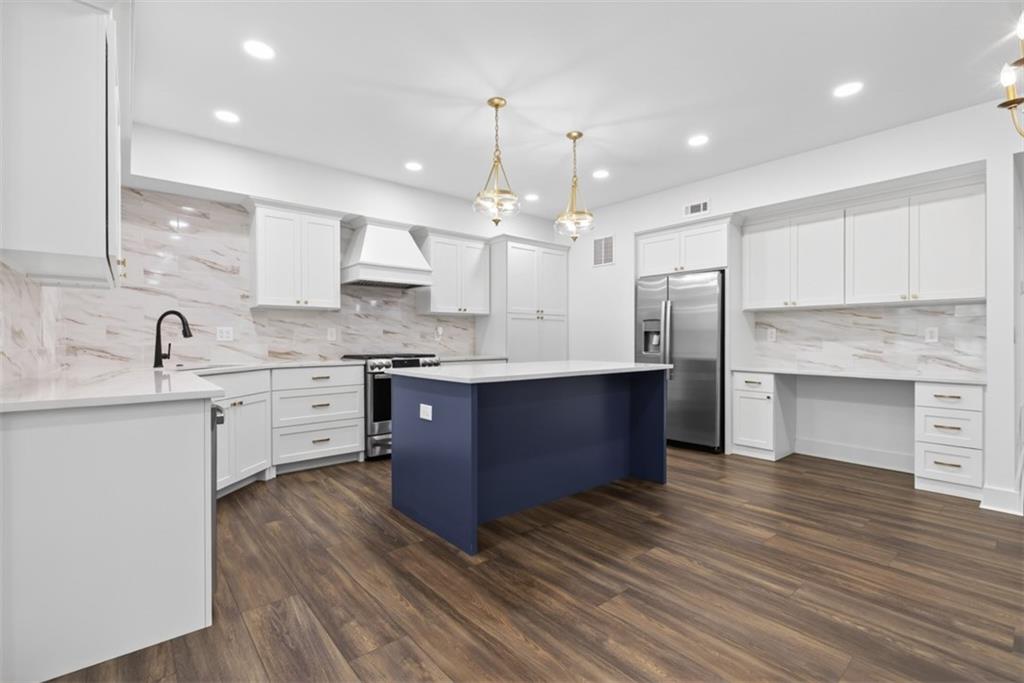 3528 North Bogan Road Buford, GA 30519 - Photo 59 of 79 a large kitchen with stainless steel appliances granite countertop a large counter top a sink dishwasher and a stove with wooden floors