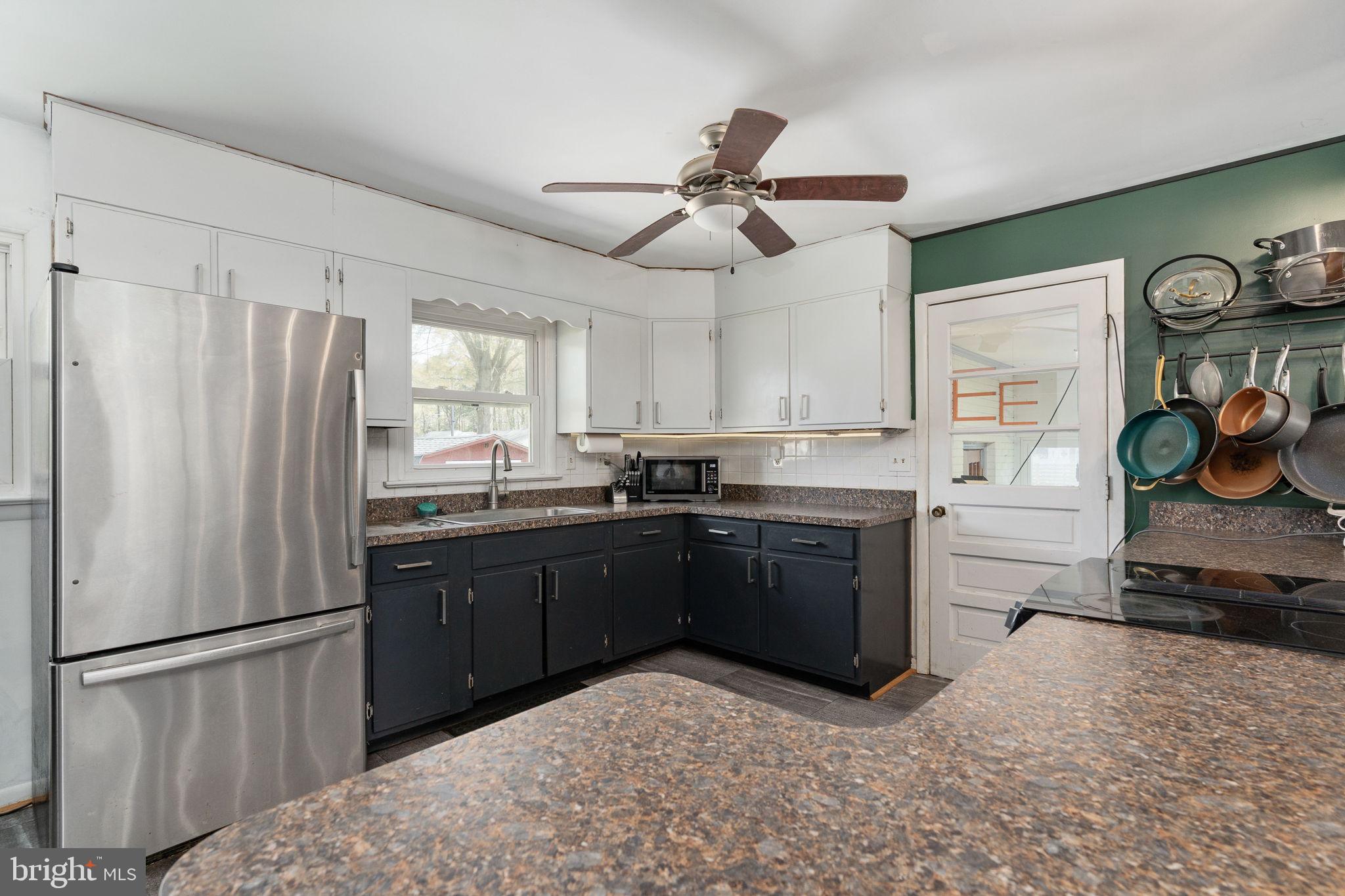 160 12th Street Colonial Beach, VA 22443 - Photo 12 of 60 a kitchen with a refrigerator a sink and cabinets