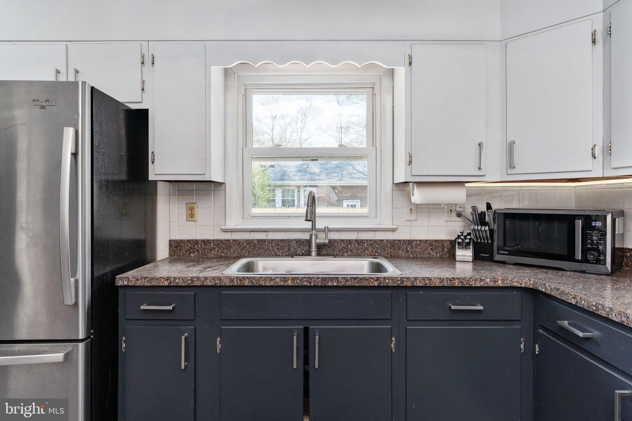160 12th Street Colonial Beach, VA 22443 - Photo 16 of 60 a kitchen with granite countertop cabinets stainless steel appliances a sink and a window