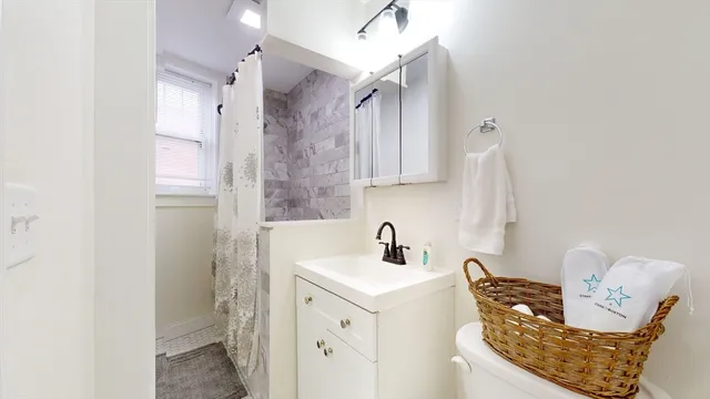 a bathroom with a sink a toilet and shower